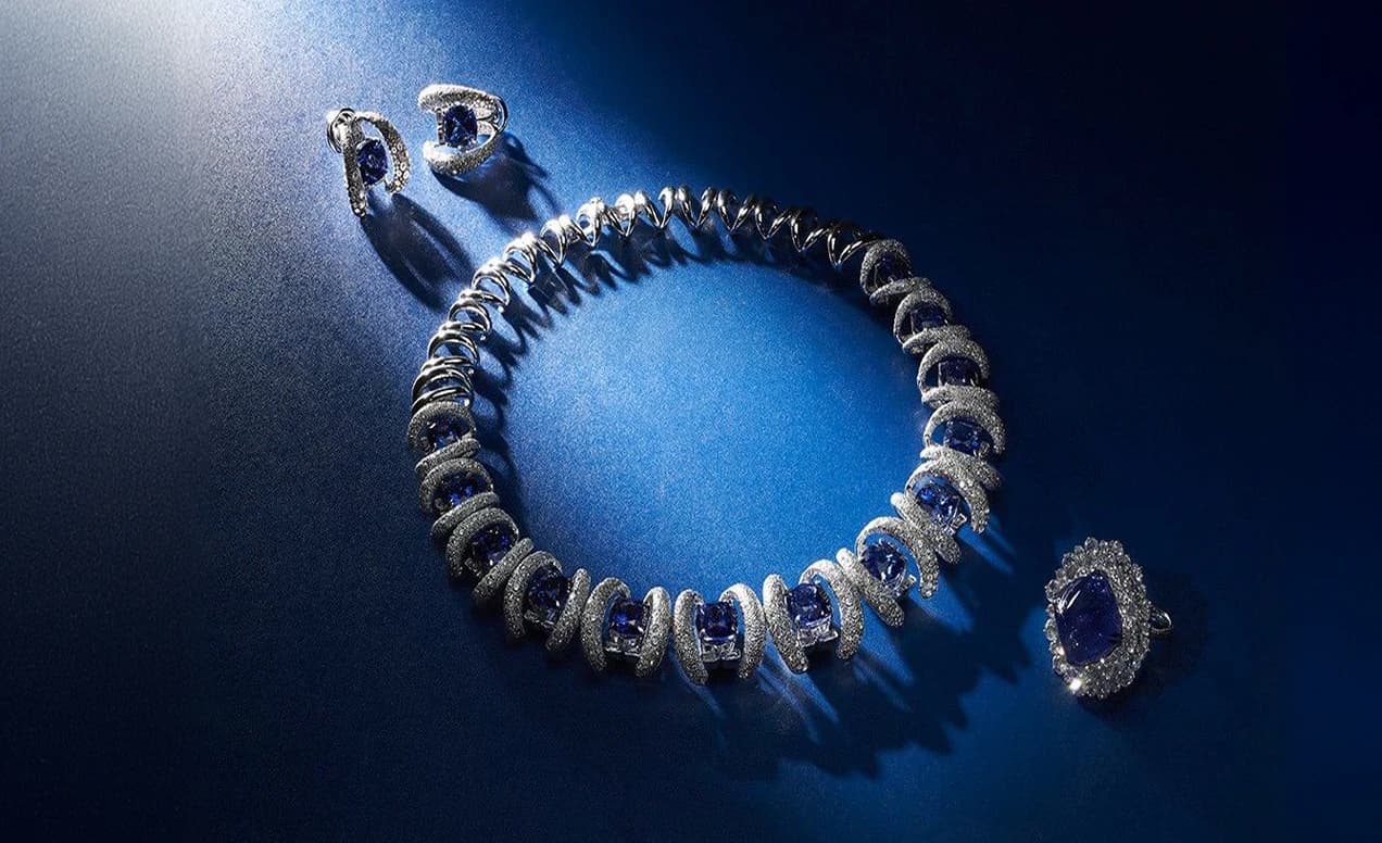 Sapphire and diamond bracelet, ring and earrings under a spotlight
