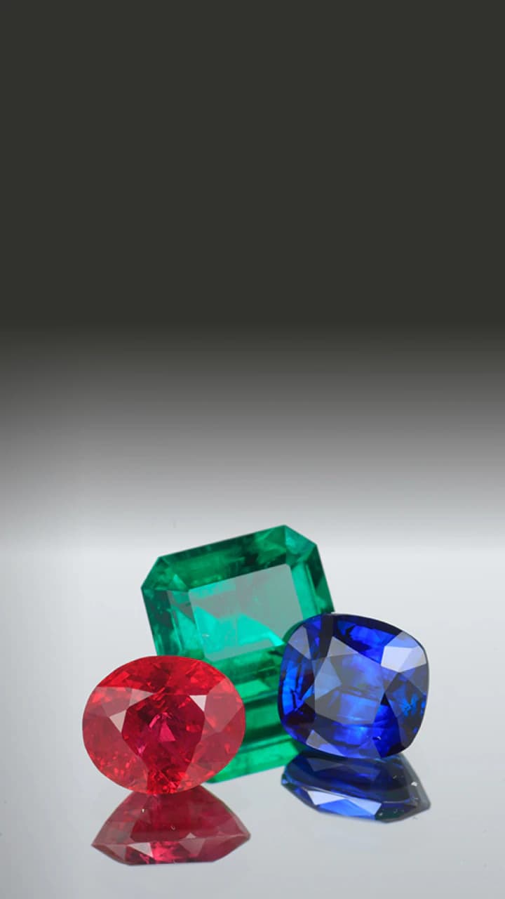 Loose precious gemstones on a gradient surface